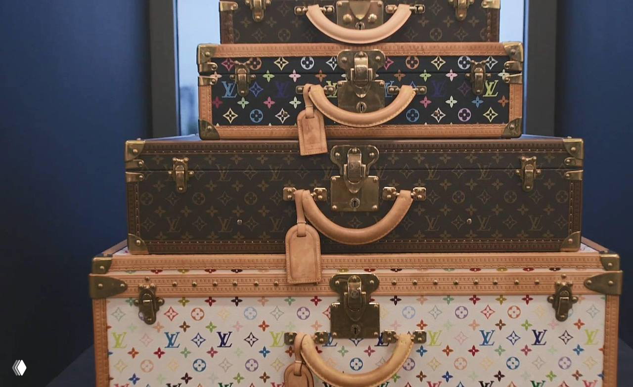 Несколько чемоданов Louis Vuitton различного размера сложены стопкой на фоне тёмной стены — предметы коллекции и декора