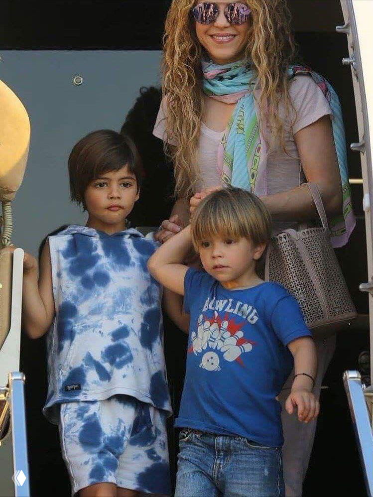 Женщина с шарфом выходит из транспорта вместе с двумя детьми, уличный снимок с деликатной атмосферой и вниманием к детям.