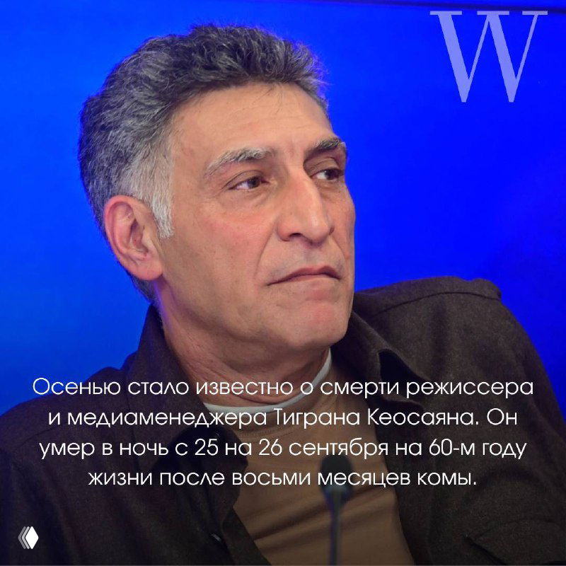 Фотография мужчины среднего возраста в тёмной одежде на синем фоне, крупный план лица, контрастный свет