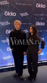 Двое людей на красной дорожке во время премьеры драмы «На льду», позируют у фотозоны с логотипами Okko и Woman.ru.