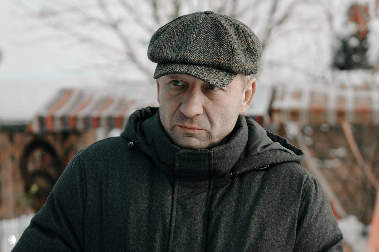 Крупный план актёра в кепке и тёплой куртке на наружной зимней локации — возможно образ одного из новых персонажей сериала
