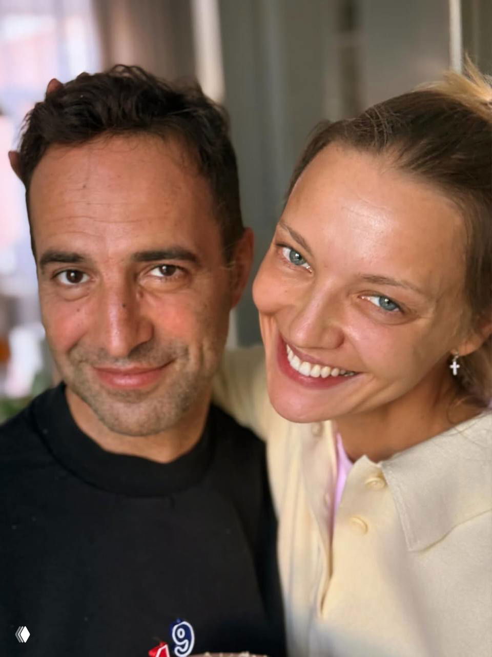 Крупный план двух улыбающихся людей в неформальной обстановке, живые эмоции и близость в кадре — портретная фотография в естественном свете.