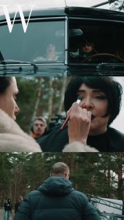 Момент подготовки на съемках: гример наносит макияж артистке в темных волосах возле автомобиля и техники на заднем плане.
