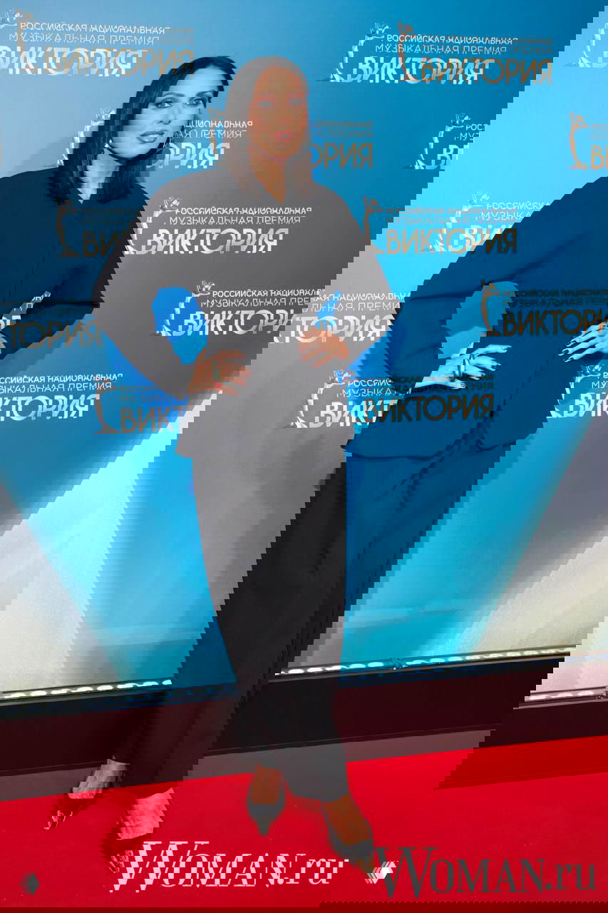 Знаменитость в чёрном костюме и классических туфлях на красной дорожке церемонии «Виктория-2026», строгий и стильный лук.