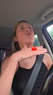 Крупный план женщины в бейсболке, пристёгнутой в автомобиле: взгляд вверх, поднятая рука, кадр из видеоблога/селфи, без указания личности