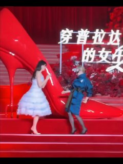 Энн Хэтэуэй и Мерил Стрип идут по красной сцене у высокой красной туфли в Шанхае; кадр демонстрирует движение и сценическое освещение промотура.