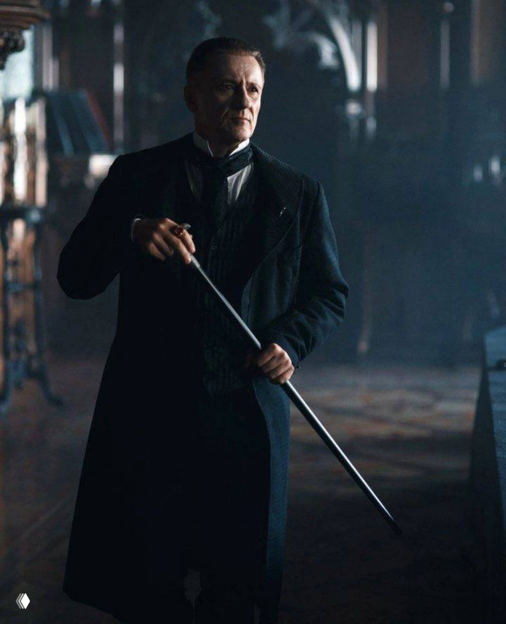 Кадр актёрской игры: персонаж в тёмном фраке с тростью в руках, интерьер напоминает классическую кинопостановку, драматическая композиция.