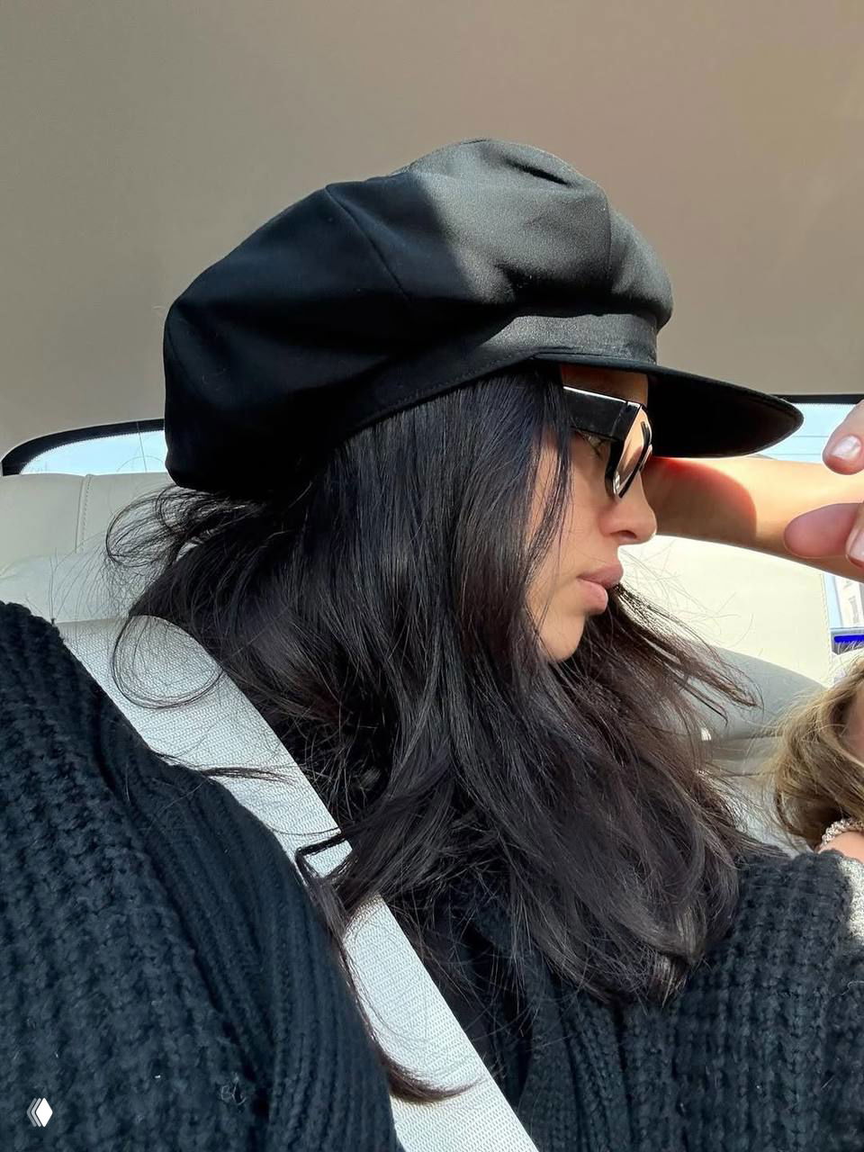 Профильный портрет в машине: женщина в черном берете и солнцезащитных очках, естественный повседневный образ в поездке по городу.