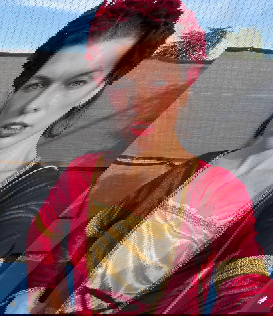 Селфи или закулисный снимок актрисы в историческом костюме: венок из цветов, естественный макияж и фон подготовительной зоны съёмок.