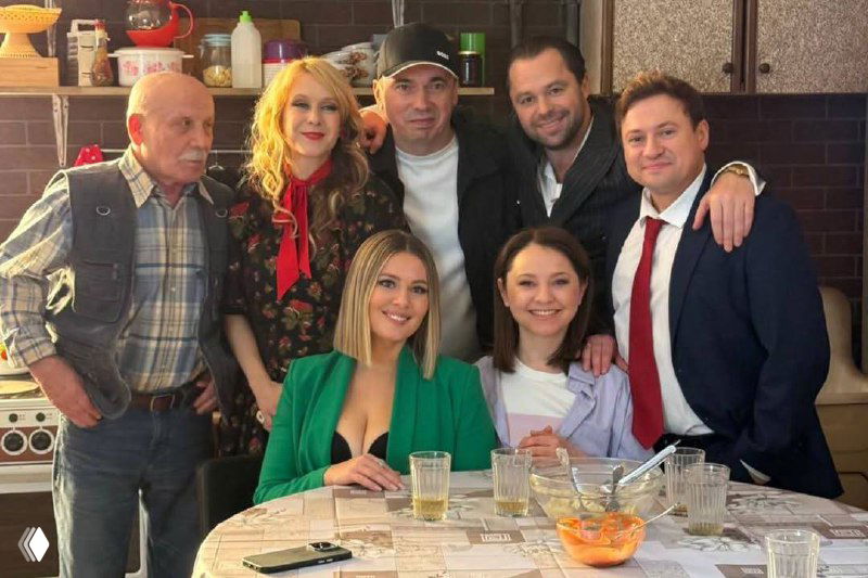 Широкий план актёров и актрис сериала «Универ»: много людей в кадре, праздничный стол и атмосфера совместной работы.