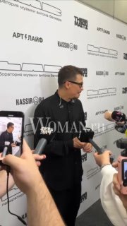 Антон Беляев у пресс‑волла во время шоу: артист в чёрной одежде отвечает на вопросы журналистов, видны микрофоны и смартфоны.