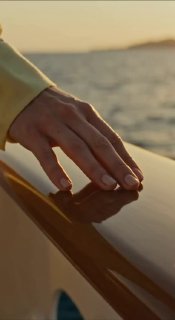Рука на борту лодки на закате — крупный план рекламной съёмки, передаёт летнюю атмосферу, ощущение лёгкости и спокойствия в промо одежды.