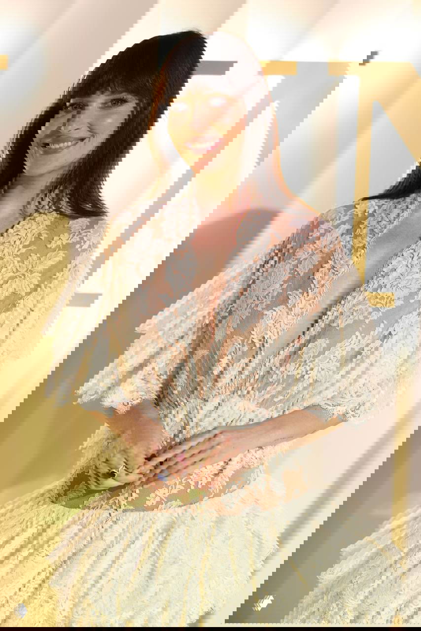 Крупный план Дакоты Джонсон: кружевной верх платья Chloé, естественный макияж и спокойная улыбка на фоне светлого оформления вечера