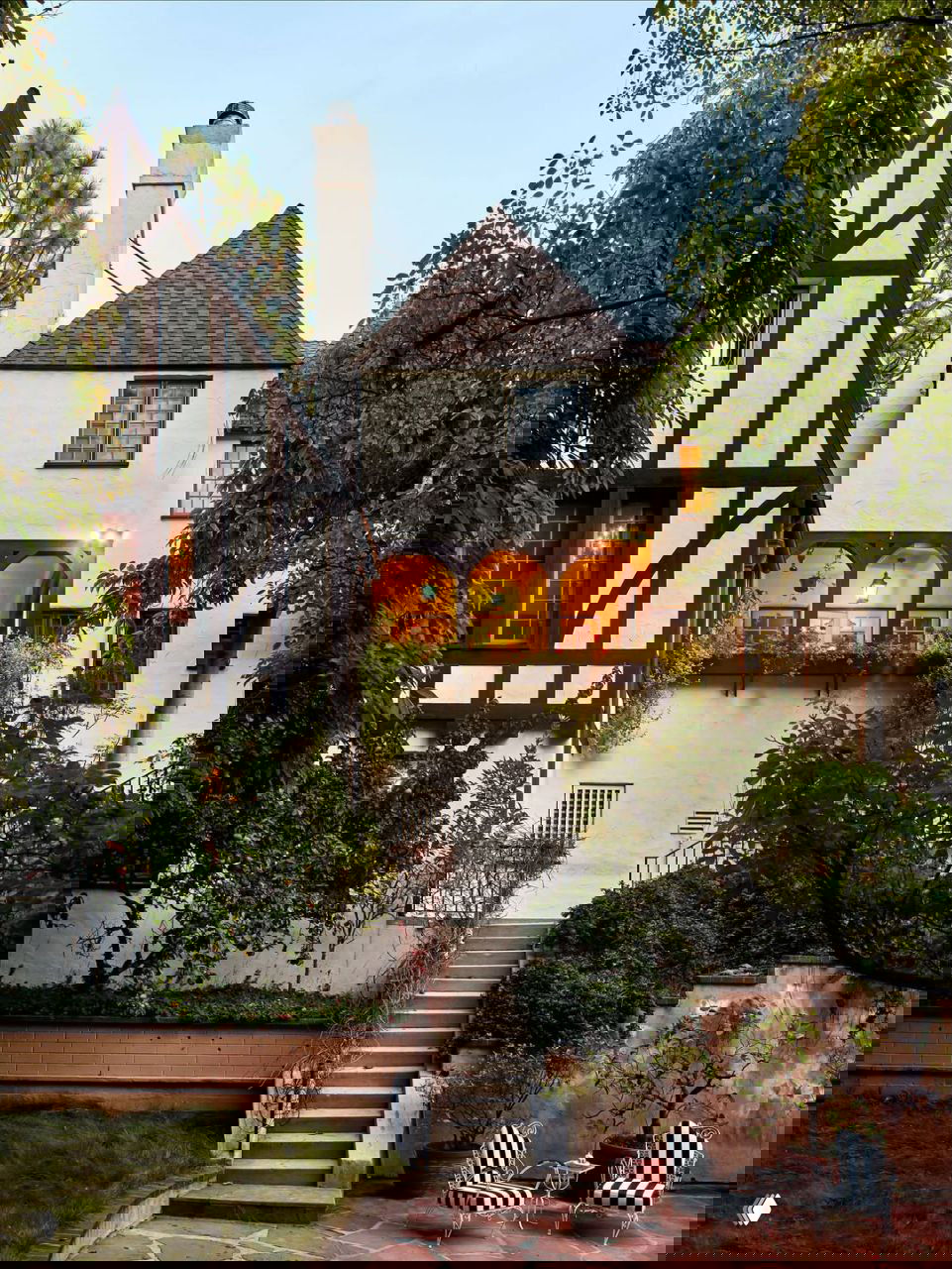 Фасад особняка в стиле Tudor Revival: деревянные балки, белые стены и садовая лестница у входа в лос-анджелесский дом