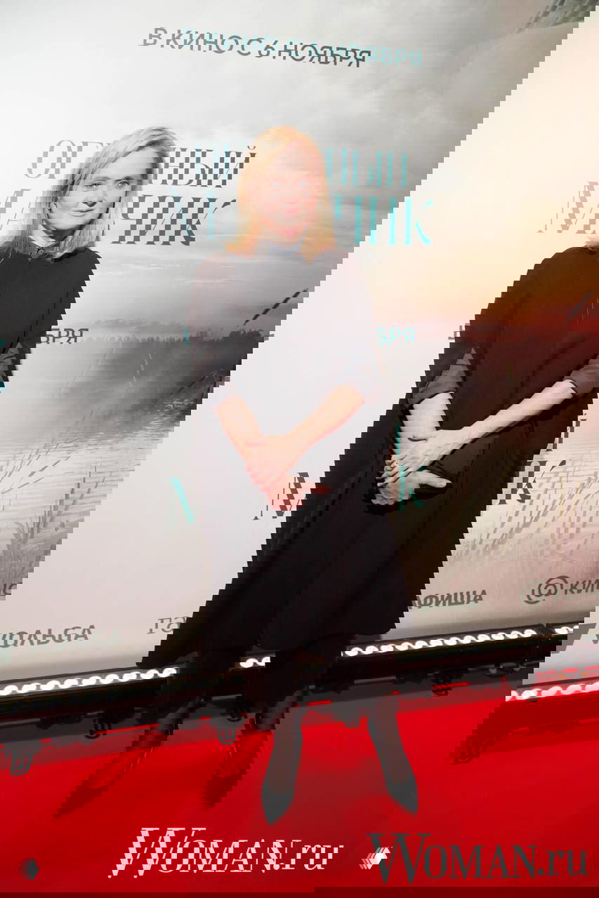 Надежда Михалкова в тёмном наряде на красной дорожке премьеры «Огненный мальчик», на заднем плане баннер с названием и датой. Фото: Woman.ru