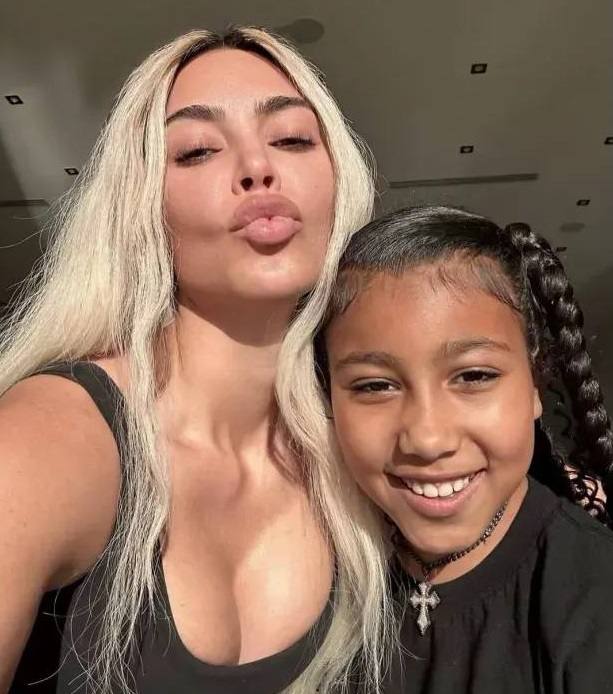 Селфи в помещении: взрослая женщина и подросток улыбаются в камеру, тёплая домашняя обстановка, дружелюбный кадр без признаков насилия.