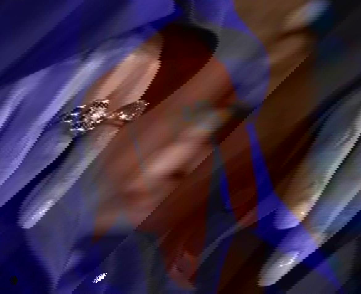 Крупный план руки Холли Берри с помолвочным кольцом и дополнительными украшениеми на пальцах: видно кольцо с камнем и аккуратный маникюр актрисы.