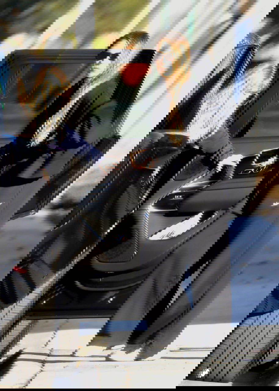 Анна Курникова выходит из автомобиля рядом с детьми: снимок показывает маму в тёмных очках и спортивном костюме у открытой двери машины.