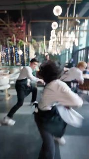 Динамичный кадр из видео: двое людей в кафе или зале танцуют с интенсивным движением, размытый фон передаёт энергетику тренда