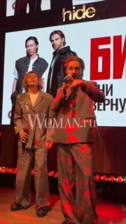 Исполнители во время выступления на закрытой вечеринке в Москве, свет, экран с постером группы и логотип Woman.ru