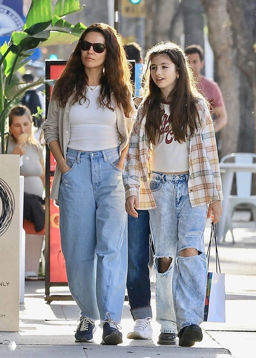 Мила Кунис идёт по улице рядом со старшей дочерью Уайетт; солнечный уличный снимок в повседневном стиле и джинсах.