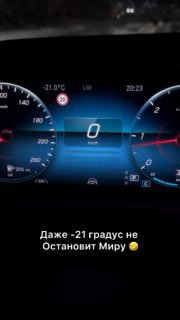 Ночная приборная панель автомобиля с подсвеченным цифровым спидометром и показанием температуры -21°C; внизу кадра видна короткая надпись про Миру.