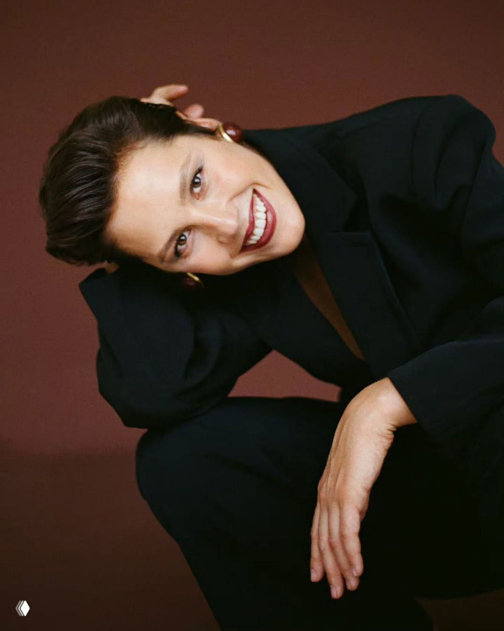 Женская улыбка в кадре крупным планом: расслабленная поза, тёплый фон, натуральный макияж и эффект живой экспрессивности.