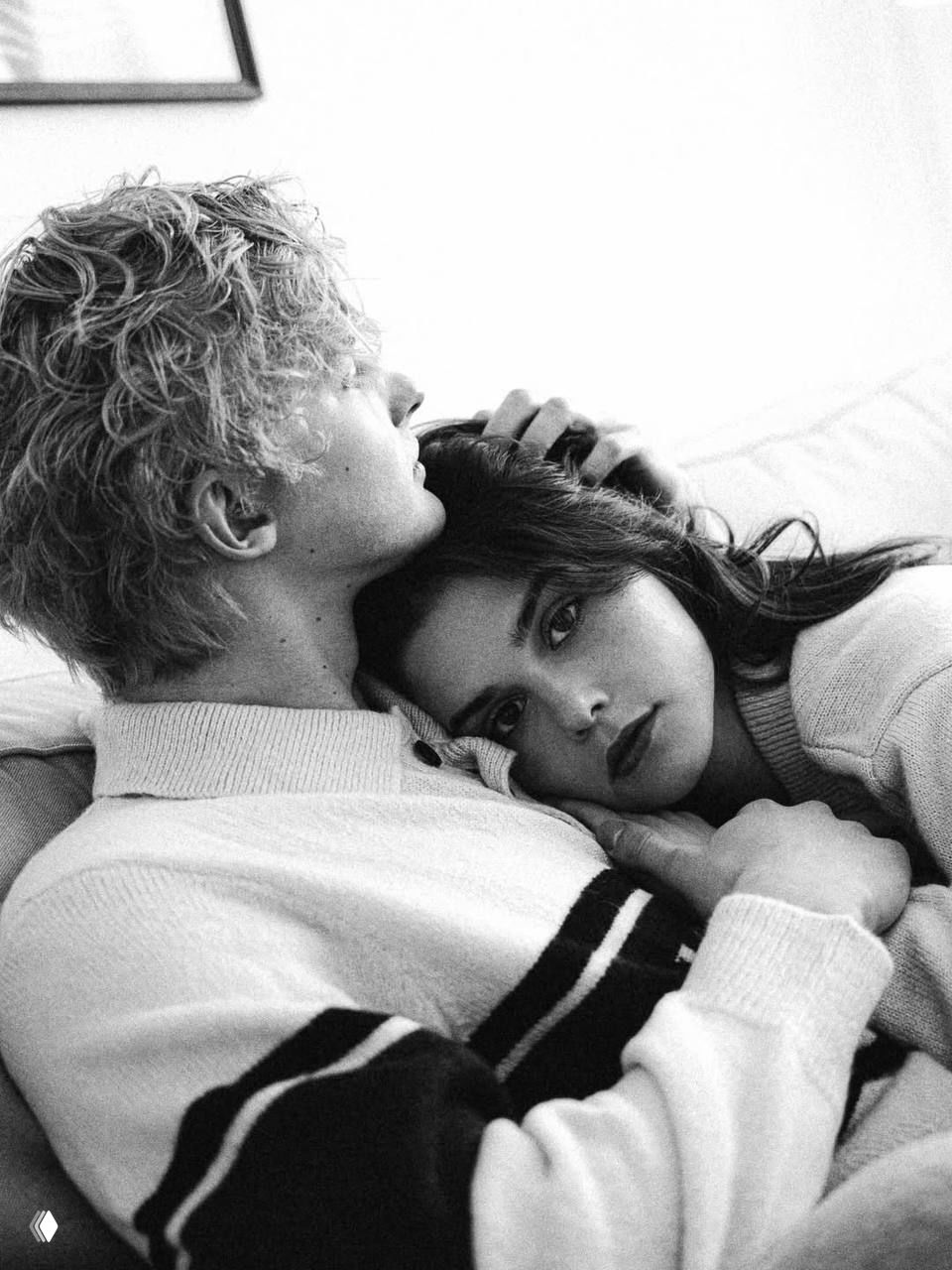 Чёрно‑белая фотография: Антон Рогачёв обнимает Полину Денисову, она прислоняет голову к его груди — интимный кадр в домашней атмосфере.