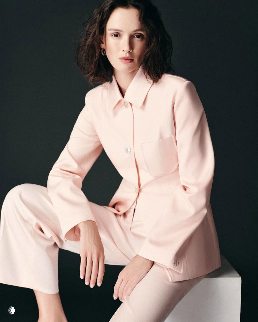 Портрет Паулины Андреевой в светло-розовом костюме на тёмном фоне — минималистичный образ и естественный макияж.