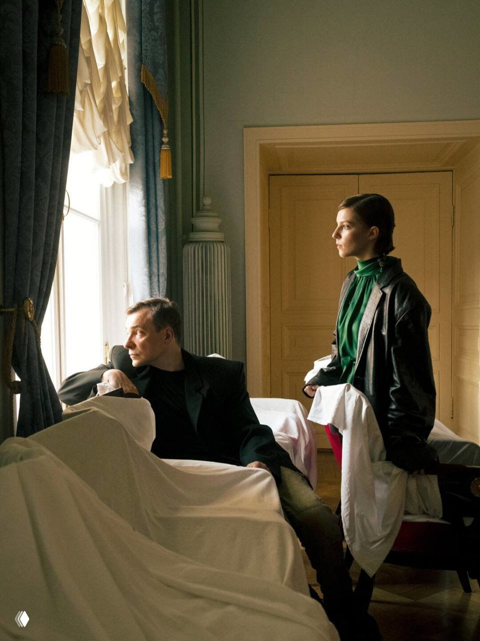 Евгений Цыганов и дочь Полина в интерьере у окна: атмосферный кадр с мягким естественным светом и накрытыми простынями предметами.