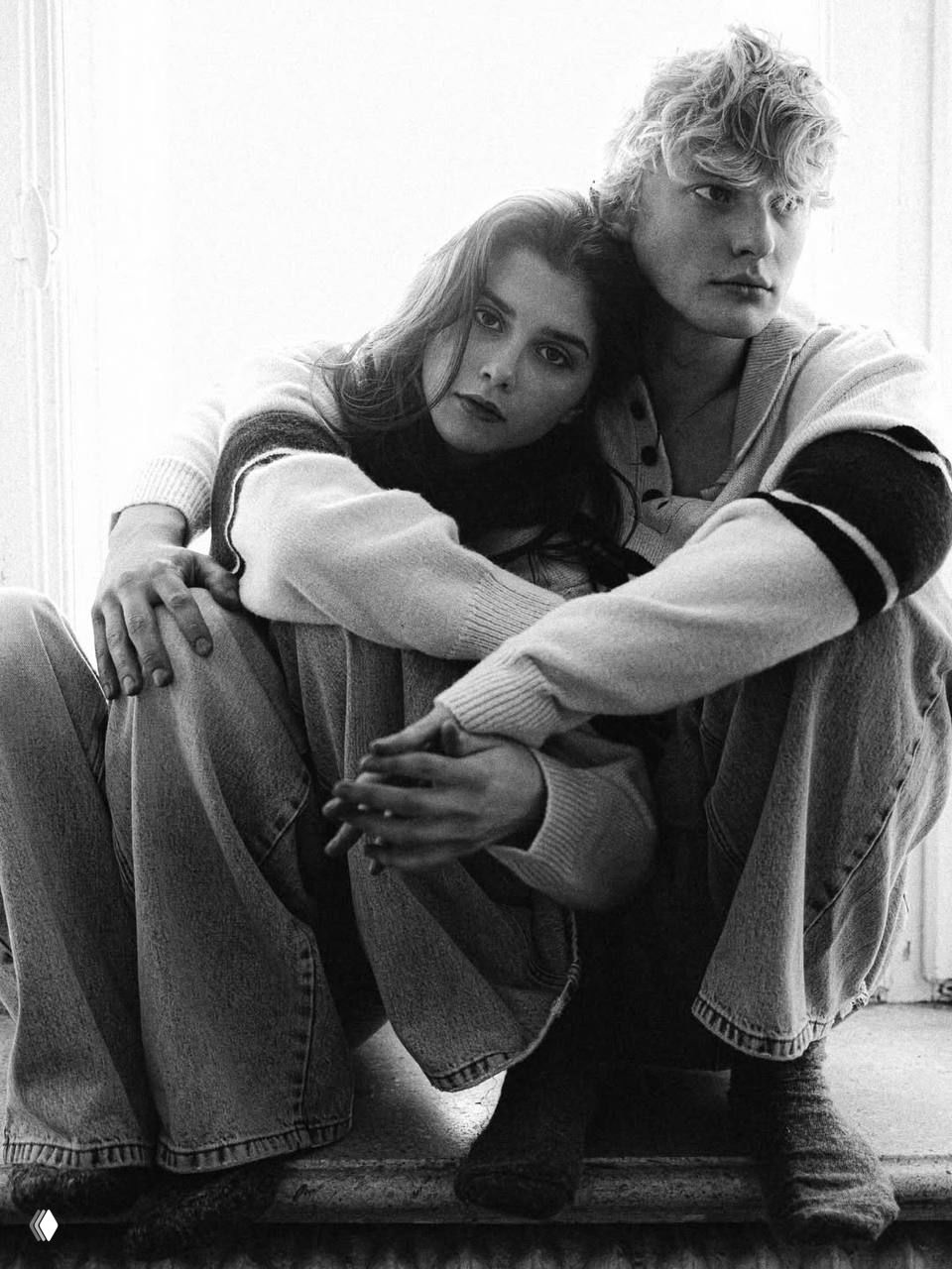 Чёрно‑белый портрет пары у окна: Полина и Антон обнимают друг друга, естественный дневной свет и спокойная поза создают романтичную атмосферу.