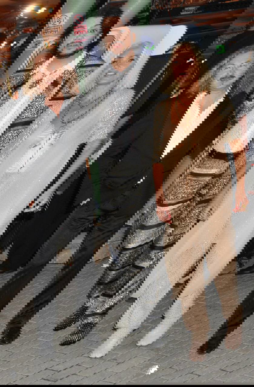 Лайма Вайкуле в светлом наряде рядом с коллегами на красной дорожке: общая сцена, вечерние костюмы и праздничная атмосфера события.