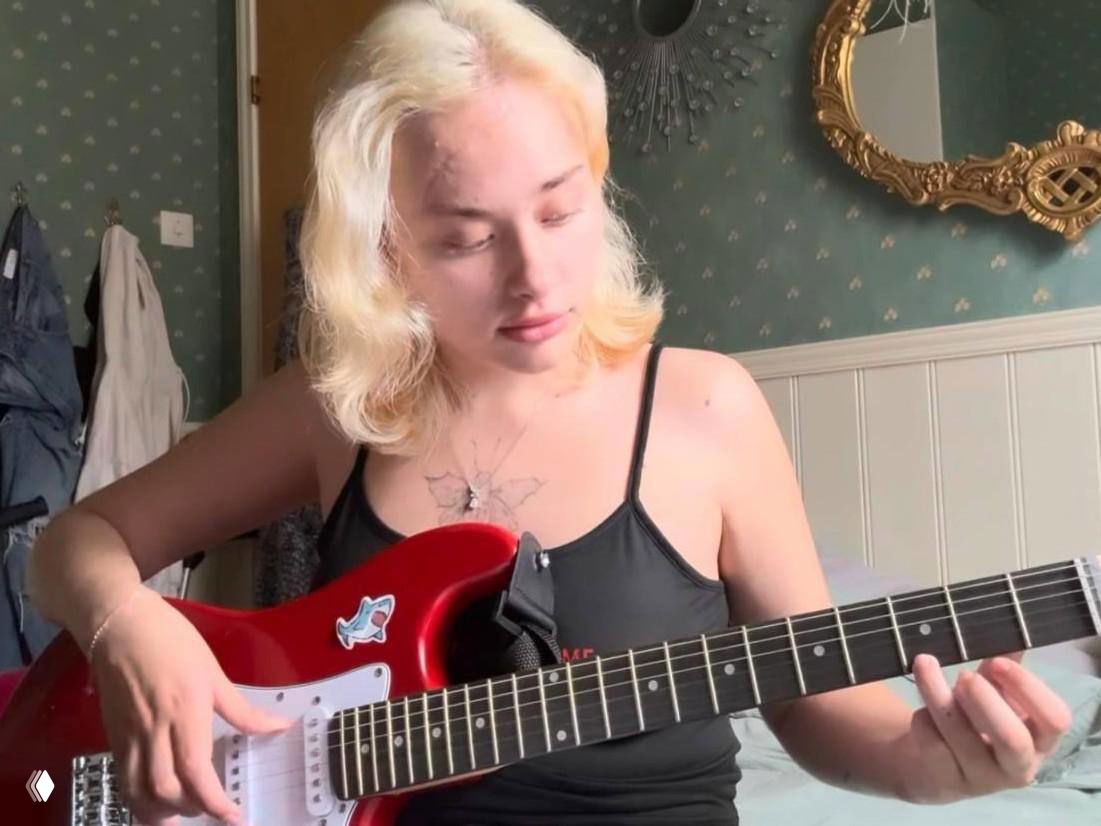 Мария Ковальчук играет на красной электрогитаре в комнате: музыкальные занятия и хобби помогают в эмоциональном восстановлении и возвращении к обычной жизни.