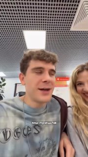 Кадр из видео: мужчина и девушка в светлом помещении, улыбаются после оформления документов; на фото видна надпись «мы пришли».