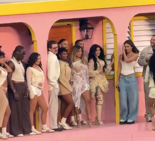 Группа приглашённых артистов на сцене Super Bowl 2026: Карди Би, Джессика Альба и другие участники возле яркой декорации в финальной сцене номера.