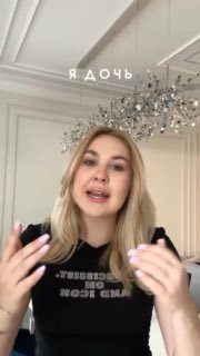 Кадр из вертикального видео: молодая женщина говорит в светлой комнате с хрустальной люстрой, жестикулирует и смотрит в камеру.