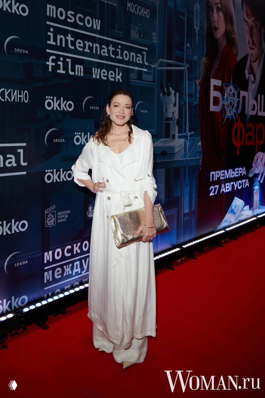 Алена Хмельницкая в лёгком образе на красной дорожке премьеры сериала «Большая фарма», портрет на фоне рекламного баннера, 24 августа, Москва.