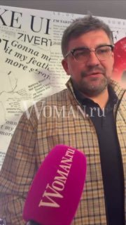 Василий Баста во время интервью у микрофона с логотипом Woman.ru; крупный план лица артиста и фон с текстовыми элементами и постером фильма.