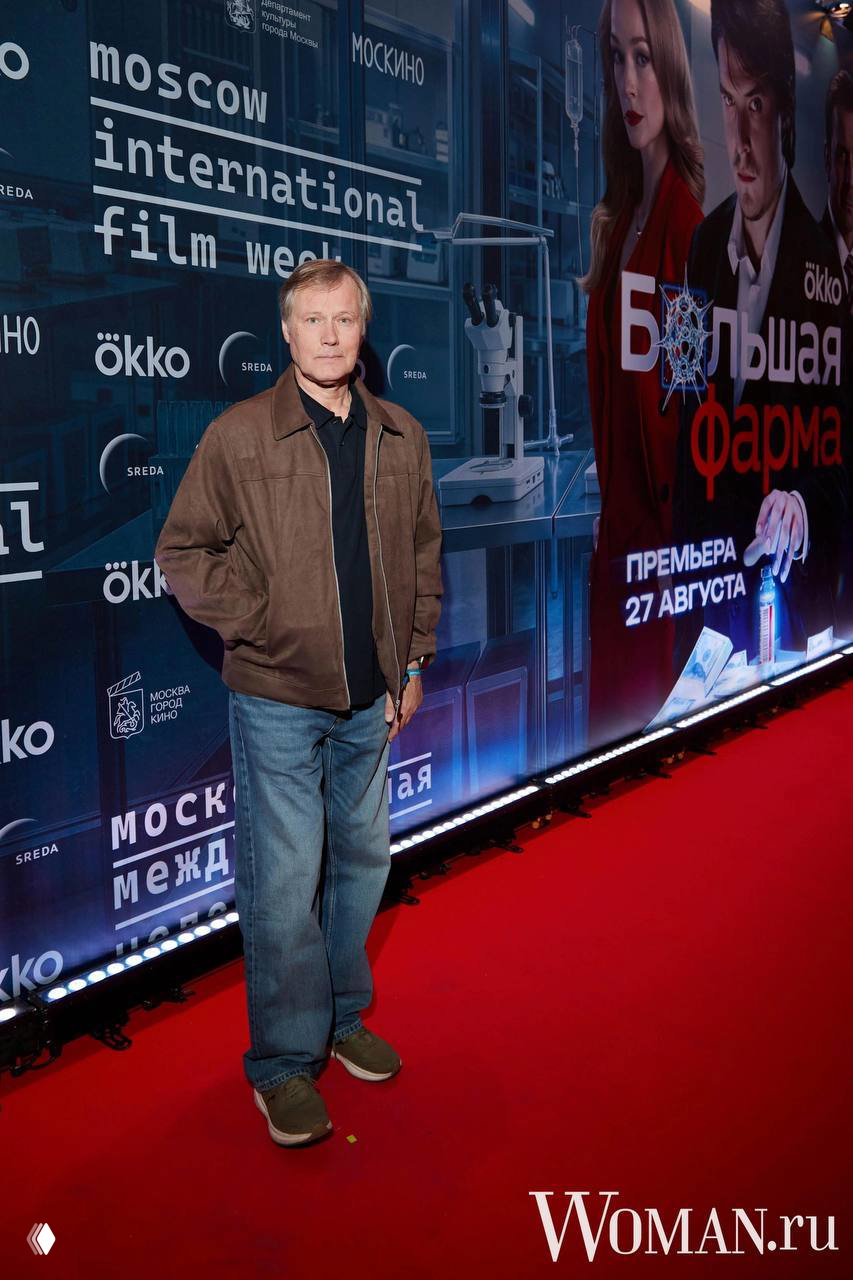 Игорь Гордин пришёл на премьеру сериала «Большая фарма» и позирует на красной дорожке возле рекламного фона кинонедели, 24 августа, Москва.