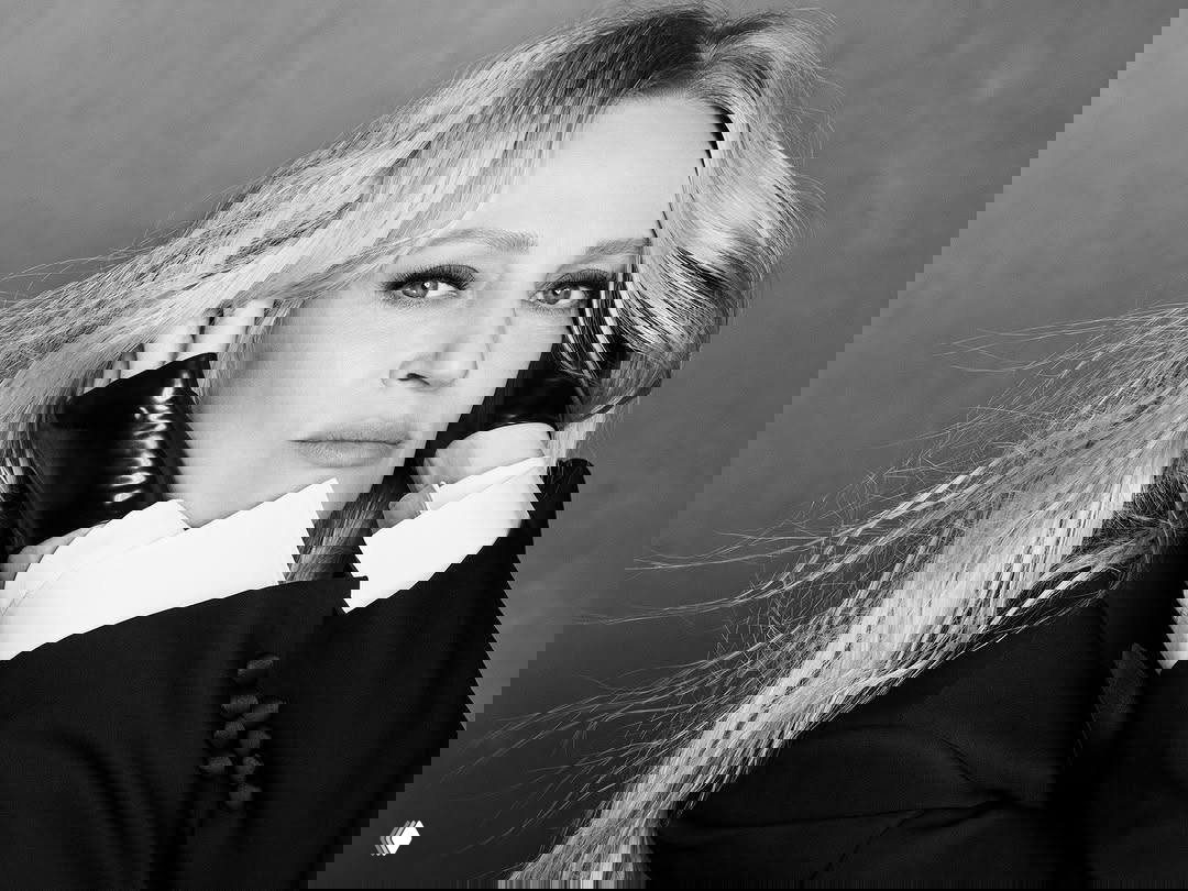 Черно‑белый близкий портрет актрисы с распущенными волосами и кожаными перчатками в модном портретном кадре для журнала