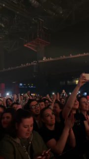 Зрители на концерте: плотная толпа, люди аплодируют и снимают на телефоны, видна атмосфера большого музыкального события