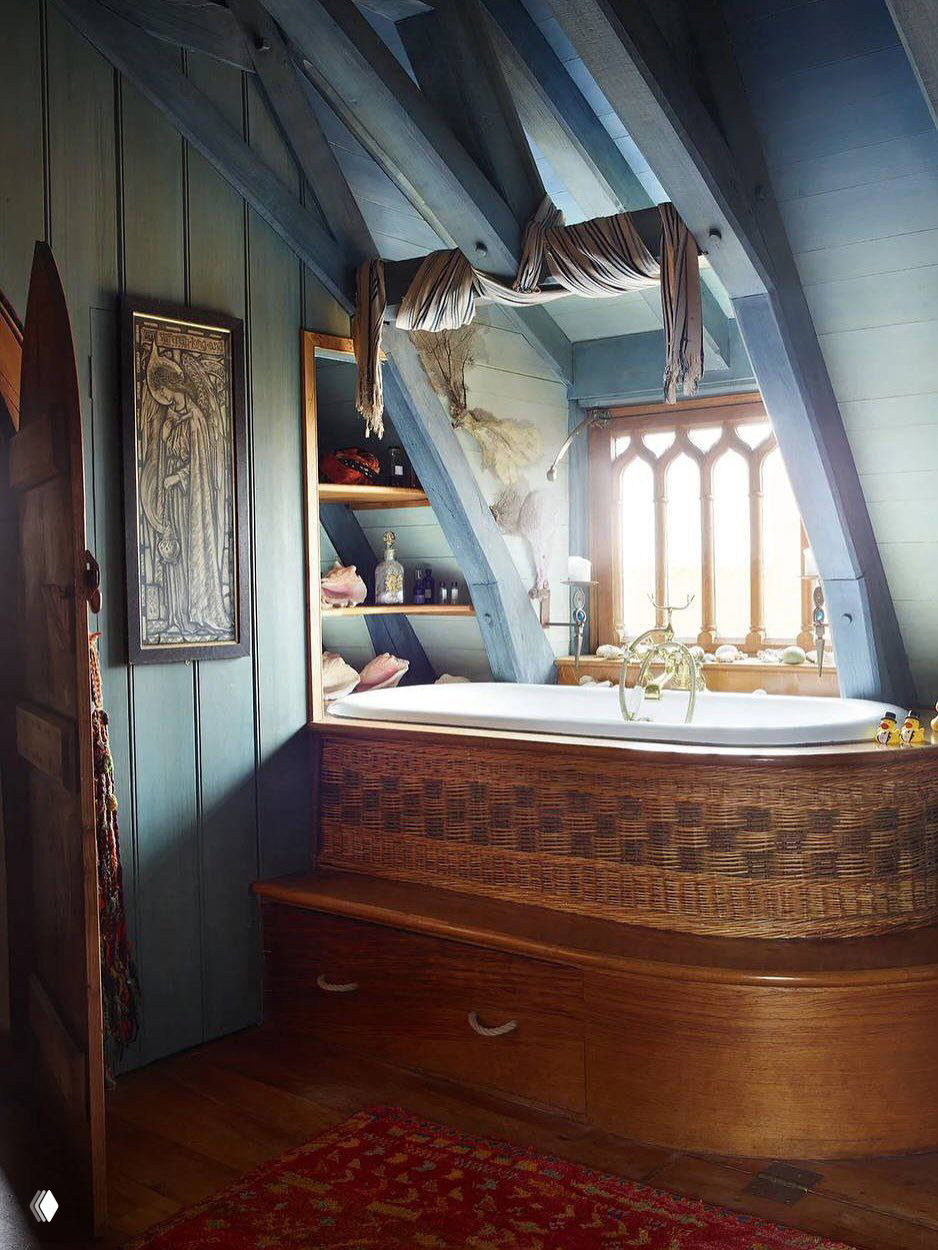 Ванная комната в лофтовом мансардном пространстве замка Килко: плетёная панель обрамляет ванну, окна с арочными переплётами и деревянная отделка.