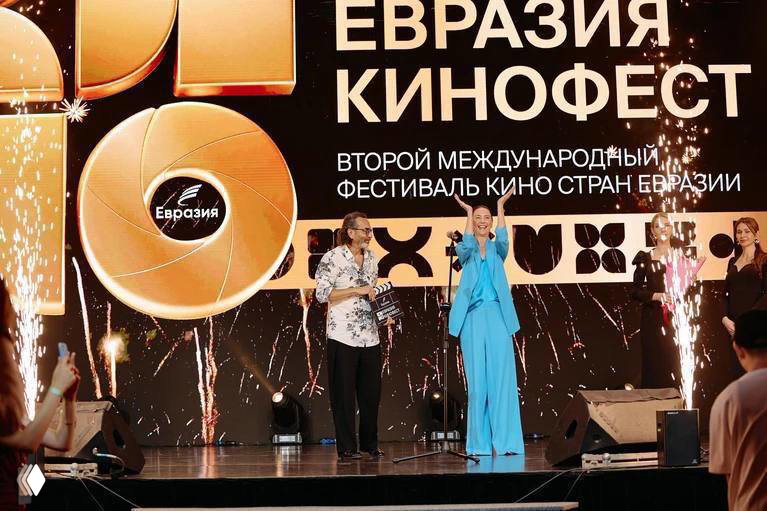 Открытие Евразия-Кинофест: ведущие и артисты на сцене, пиротехника и большой баннер с названием фестиваля