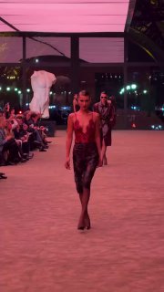 Модель Белла Хадид идёт по подиуму на шоу Saint Laurent, вечерний показ с минималистичной сценой и зрителями по бокам.