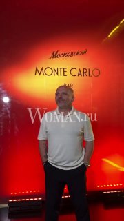 Мужчина в светлой футболке стоит на красном фоне с надписью «Monte Carlo Bar», сценическая подсветка и логотип заведения, момент открытия гастропространства в Москве.