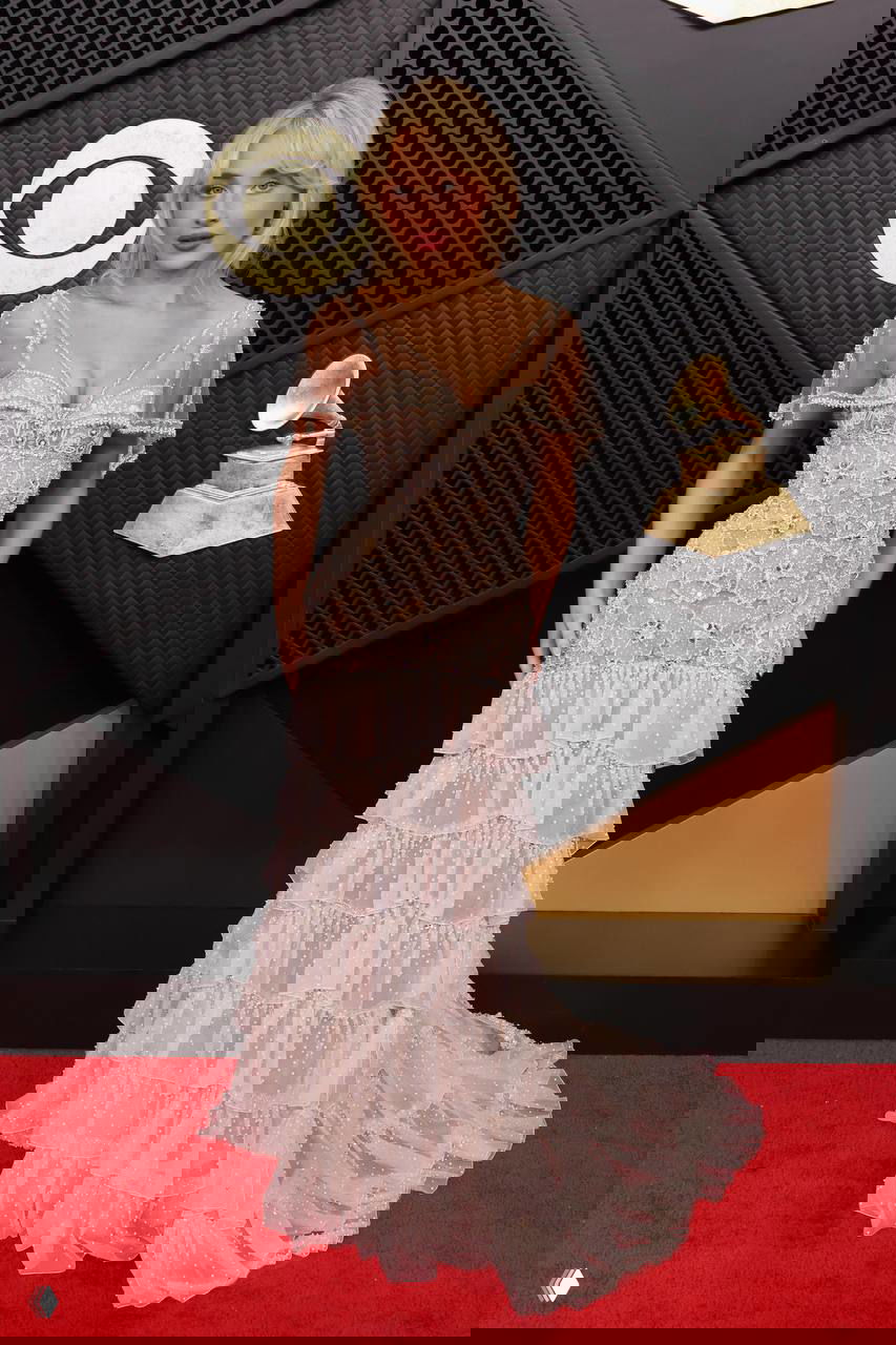 Сабрина Карпентер в светло‑розовом многоярусном платье с рюшами и прозрачными деталями на красной дорожке «Грэмми — 2026».