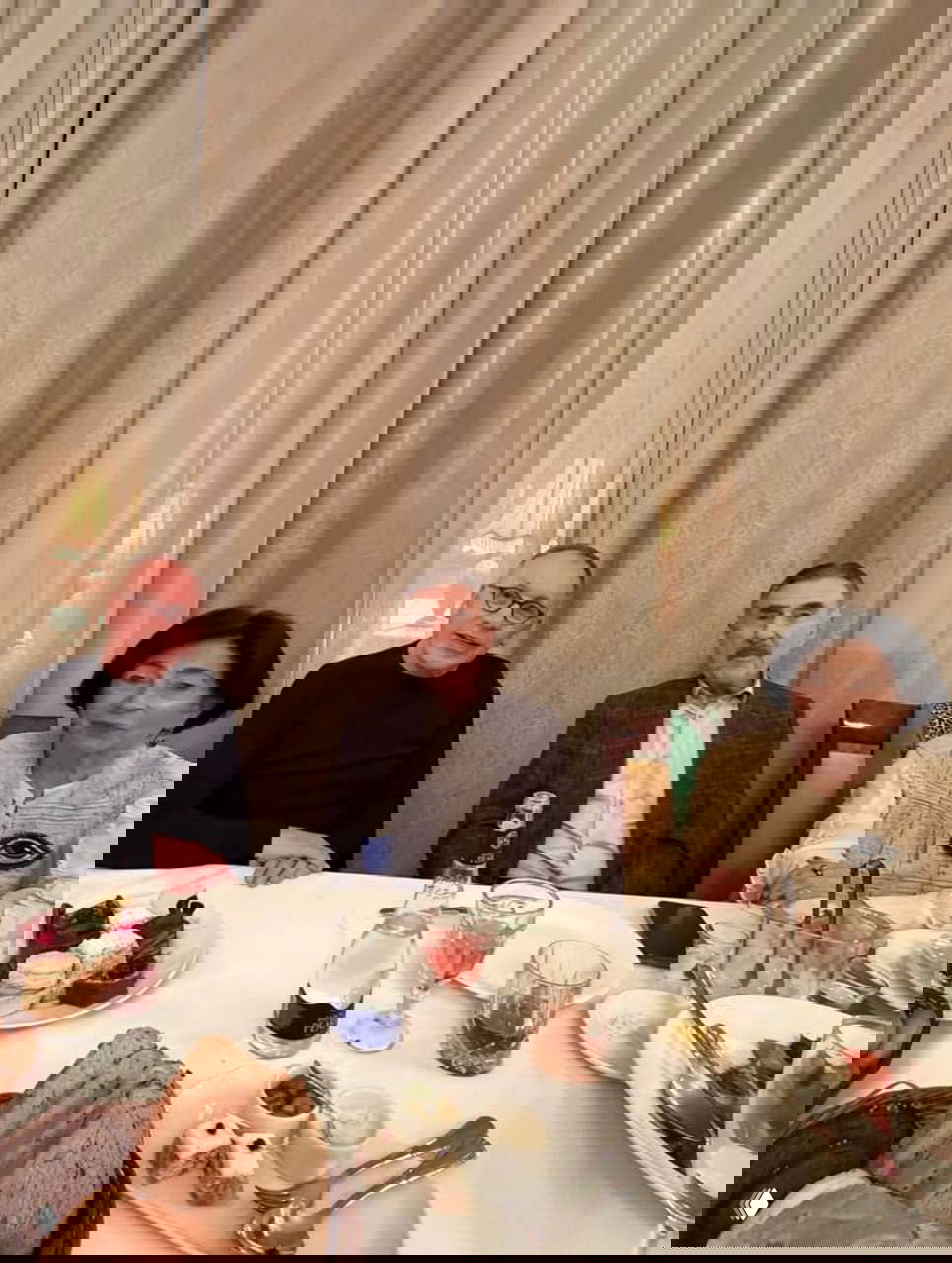 Крупный план за столом: Леонид Каневский в центре кадра вместе с гостями, на столе закуски, напитки и праздничная сервировка.