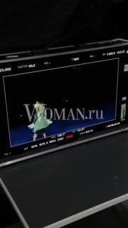 Экран монитора с водяным знаком Woman.ru: кадр с артистом в белом костюме во время съёмок клипа «Эпилог», закулисье.