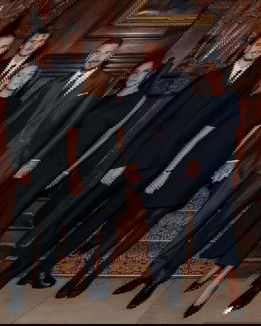 Семейный портрет Бекхэмов в официальных тёмных нарядах внутри торжественного интерьера: родители и дети стоят вместе после церемонии.