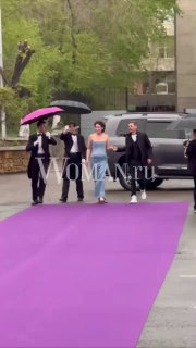 Екатерина Волкова и Денис Никифоров идут по фиолетовой дорожке под зонтами на церемонию открытия Забайкальского кинофестиваля в Чите.